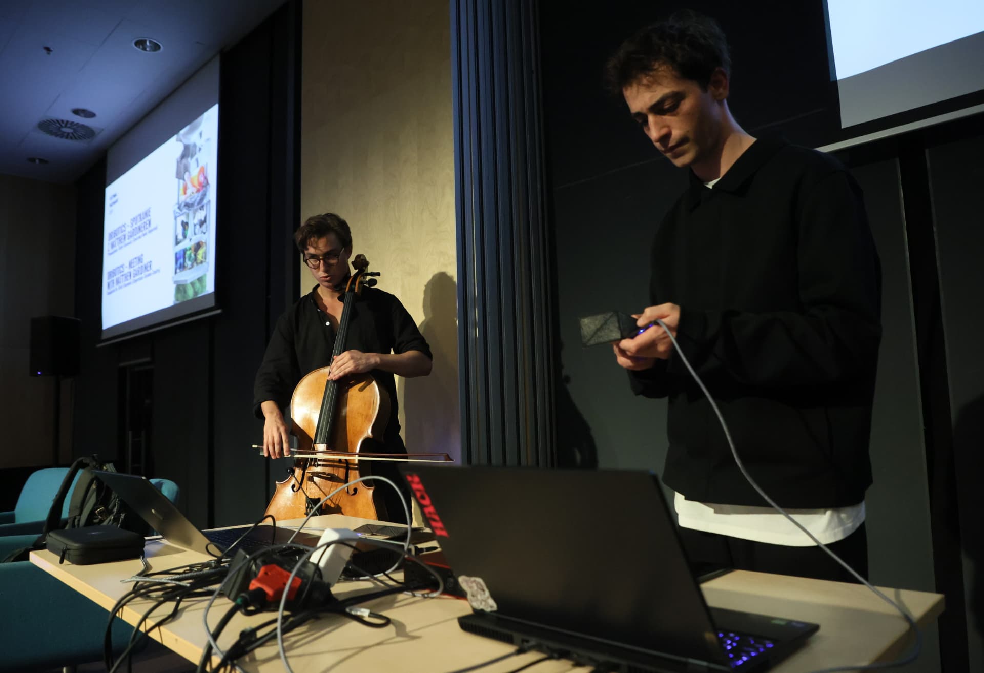 Cellist and electronic performer with a handheld sensor at Festiwal Przemiany 2024
